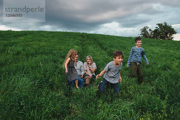 Fünfköpfige Familie geniesst die freie Natur auf grünem Grasfeld