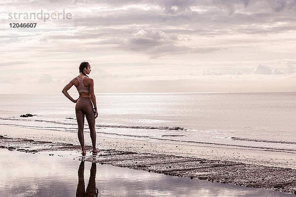 Junge Läuferin am Wasser mit Blick aufs Meer