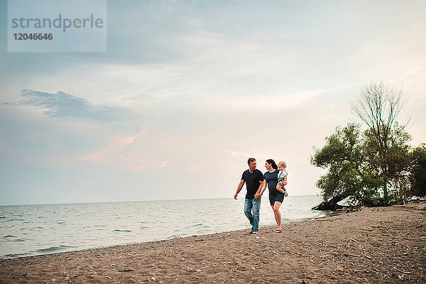 Schwangeres Paar schlendert mit männlichem Kleinkind am Strand entlang  Ontariosee  Kanada