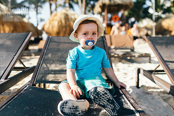 Porträt eines kleinen Jungen auf einer Sonnenliege sitzend