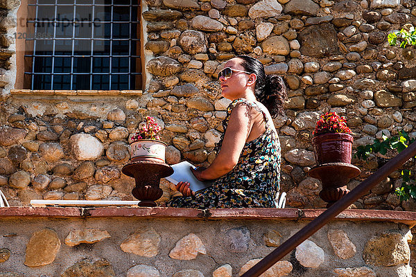 Reife Frau  die von der Terrassenmauer hinaussieht  Begur  Katalonien  Spanien