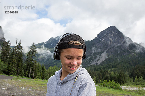 Porträt eines Teenagers in ländlicher Umgebung  der Kopfhörer trägt