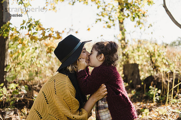 Mutter küsst und umarmt Tochter