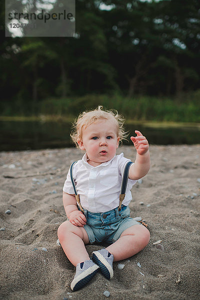 Porträt eines männlichen Kleinkindes am Sandstrand sitzend  Ontariosee  Kanada