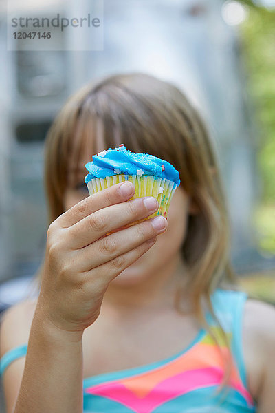 Junges Mädchen hält Muffin