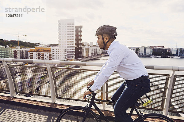 Seitenansicht des Radfahrers auf der Fußgängerbrücke gegen den Himmel