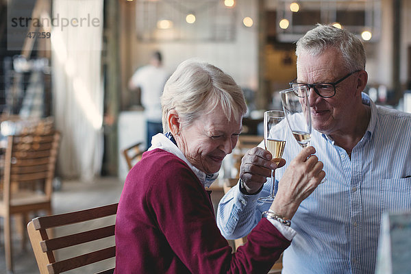 Liebende ältere Männer und Frauen genießen Champagner im Restaurant