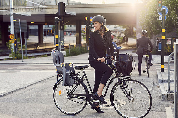 Geschäftsfrau mit Fahrrad auf der Straße in der Stadt