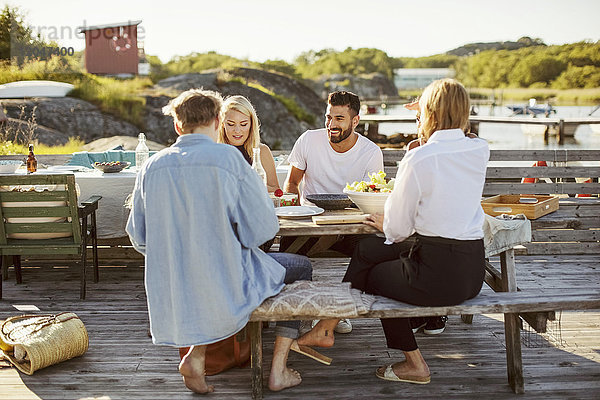 Junge multiethnische Freunde beim Sommeressen im Hafen