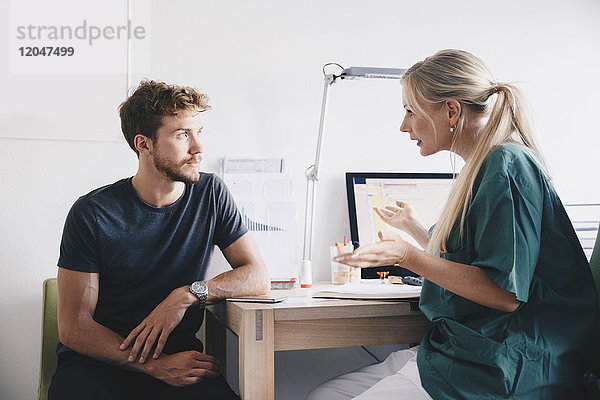 Krankenschwester erklärt dem jungen Patienten in der Praxis im Krankenhaus