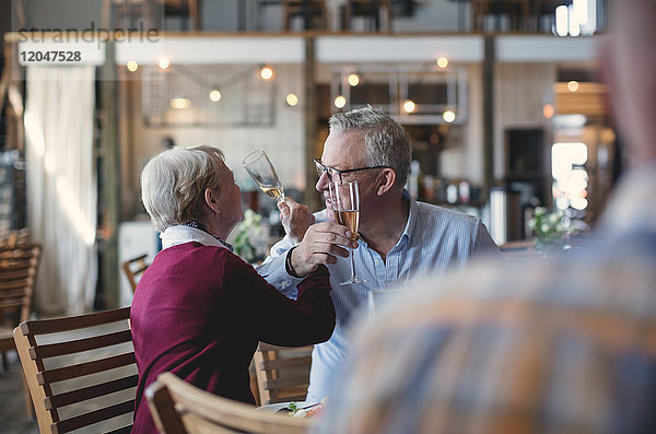 Liebevolles Seniorenpaar trinkt Champagner im Restaurant