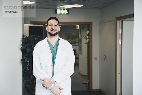 Porträt eines selbstbewussten jungen Arztes im Krankenhausflur