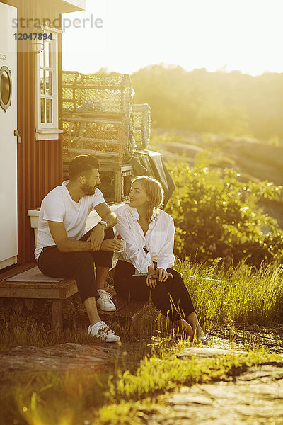 Junges Paar beim Reden in der Blockhütte an einem sonnigen Tag