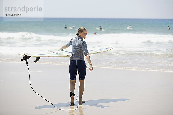 Frau geht mit Surfbrett auf das Wasser zu  Noosa Beach  Australien