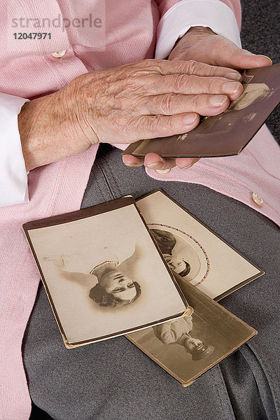 Frau hält alte Fotografien