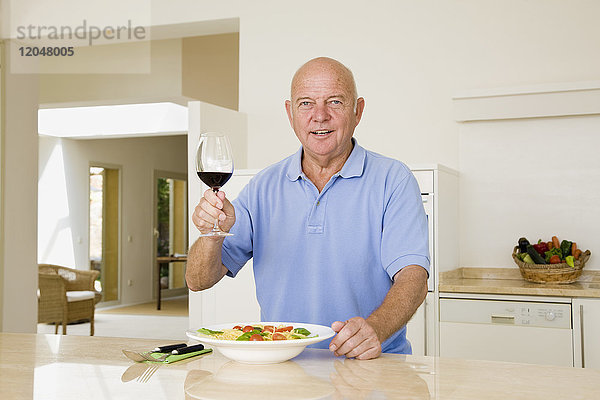Porträt eines Mannes  der ein Glas Wein hebt