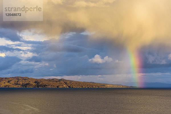 Regenbogen über der Küstenlinie auf der Isle of Skye in Schottland  Vereinigtes Königreich
