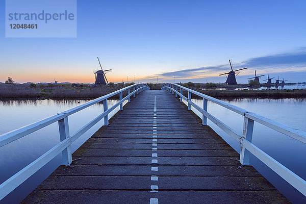 Holzbrücke mit Windmühlen in der Morgendämmerung  Kinderdijk  Südholland  Niederlande