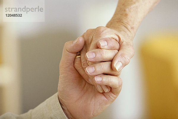 Nahaufnahme eines älteren Paares beim Händchenhalten