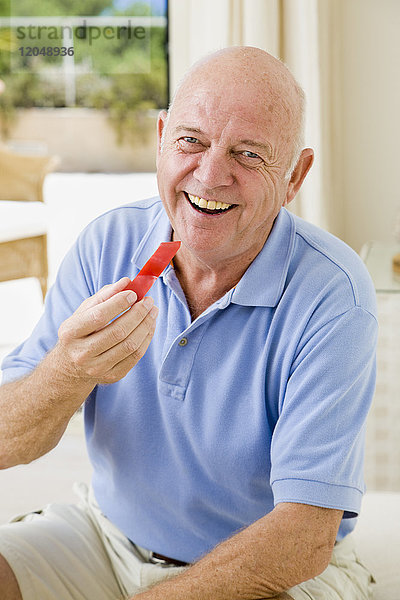 Porträt eines Mannes  der rote Paprika isst