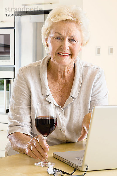 Porträt einer Frau mit Wein und Laptop-Computer