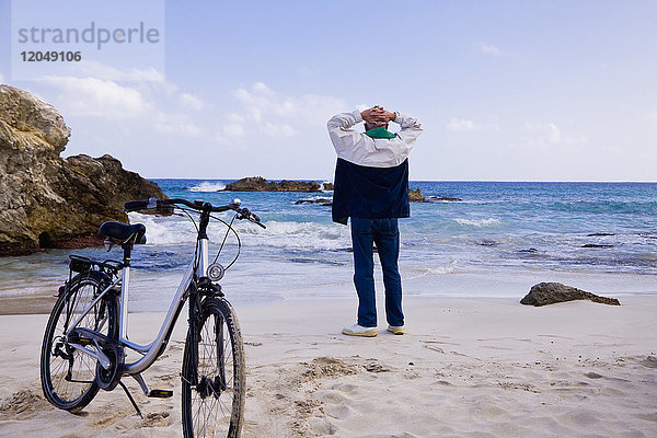 Mann mit Fahrrad am Strand