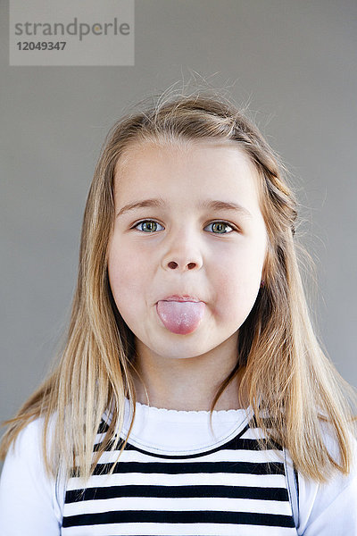 Porträt eines Mädchens mit herausgestreckter Zunge
