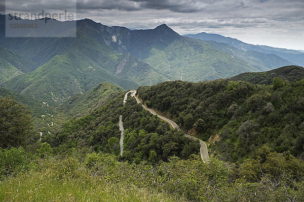 Landschaftliche Ansicht einer Gebirgsstraße  State Route 41  mit dem Devil's Peak der Sierra Mountains im Hintergrund  Kalifornien  USA