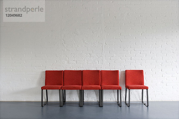 Rote Stühle an der Wand