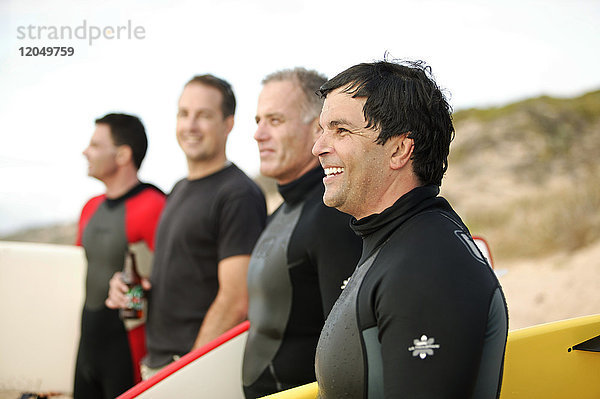 Männer am Strand mit Surfbrettern