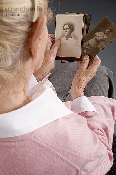 Frau hält alte Fotografien