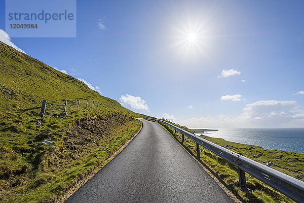 Typische schottische Landschaft auf der Isle of Skye mit Sonnenschein auf einer Küstenstraße  Schottland  Vereinigtes Königreich