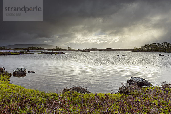 Uferlinie eines Sees in einer Moorlandschaft mit stürmischem Himmel im Rannoch Moor in Schottland  Vereinigtes Königreich