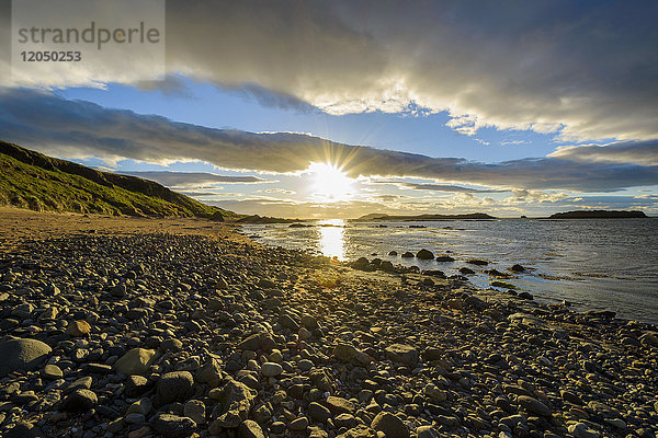Sonnenschein über einer Bucht mit felsigem Strand bei Sonnenuntergang in North Berwick am Firth of Forth in Schottland  Vereinigtes Königreich