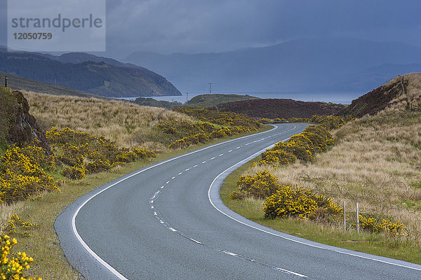 Kurvenreiche Landstraße mit bedecktem Himmel im Frühling auf der Isle of Skye  Schottland  Vereinigtes Königreich