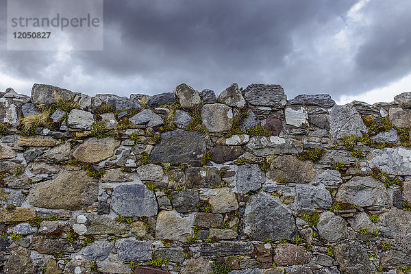 Nahaufnahme einer Steinmauer einer verlassenen Kirche mit Sturmwolken auf der Isle of Skye in Schottland  Vereinigtes Königreich