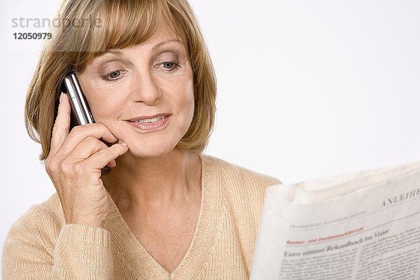 Frau mit Mobiltelefon und Zeitungspapier