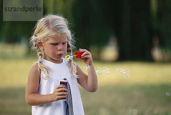 Kleines Mädchen bläst Seifenblasen