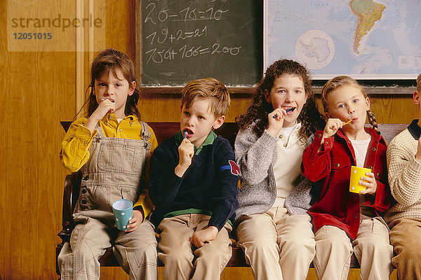 Kinder beim Zähneputzen im Klassenzimmer