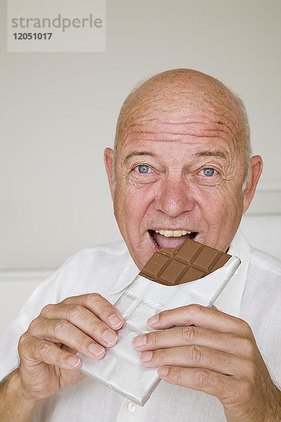Mann isst Schokoladenriegel