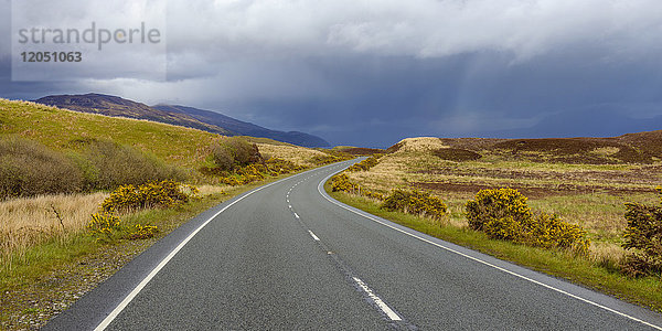 Landstraße mit Regenwolken im Frühling auf der Isle of Skye in Schottland  Vereinigtes Königreich