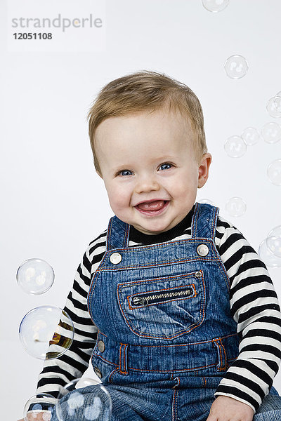 Porträt eines von Seifenblasen umgebenen kleinen Jungen
