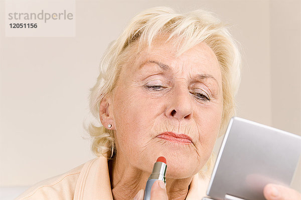 Frau trägt Lippenstift auf