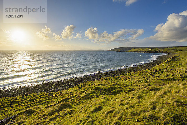 Felsiger Küstenstrand mit Sonnenschein über dem Meer auf der Isle of Skye in Schottland  Vereinigtes Königreich