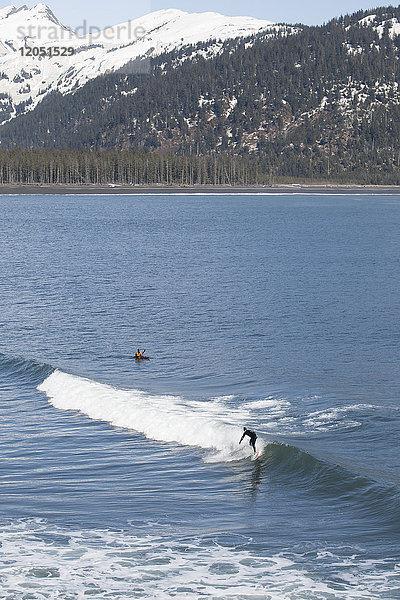 Surfer und Kajakfahrer in den Gewässern der Außenküste der Kenai-Halbinsel  Süd-Zentral-Alaska  USA