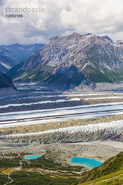 Blick auf den Kennicott-Gletscher und die angrenzenden Berge im Wrangell-St. Elias National Park. Kleine bunte Flecken neben dem linken See sind Zelte; Alaska  Vereinigte Staaten von Amerika