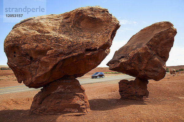 Geologische Formation Balancing Rocks in der Nähe von Lee's Ferry  Az auf indianischem Land  im Hochsommer mit einem Auto auf dem Highway und blauem Himmel dahinter; Arizona  Vereinigte Staaten von Amerika