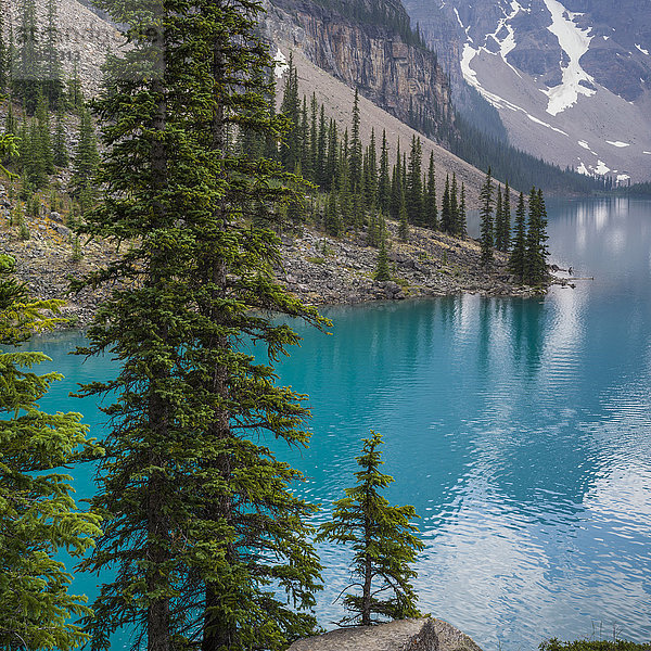 Das atemberaubende blaue Wasser des Moraine Lake mit Schnee auf den schroffen Bergen im Banff National Park; Lake Louise  Alberta  Kanada