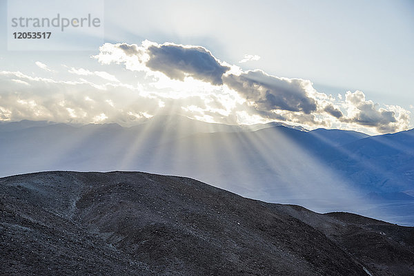 Lichtströme hinter einer Wolke im Death Valley National Park  in der Nähe des Artists' Drive; Kalifornien  Vereinigte Staaten von Amerika