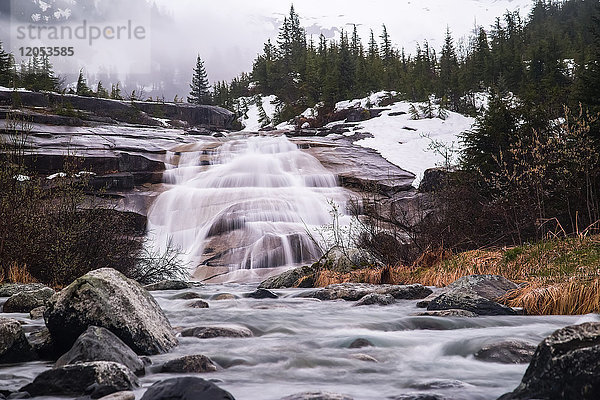 Wasserfall Down Rock Slab Near Nellie Juan Glacier On Cloudy Day With Snow; Whittier  Alaska  Vereinigte Staaten von Amerika